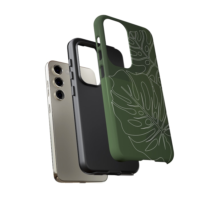 May include: A green phone case with a white outline of tropical leaves. The case is shown with a black phone case and a gold phone.