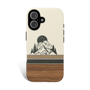 May include: A phone case with a mountain and sun design. The top section is off-white with a black mountain and sun graphic. Below is a patterned band and a wood-grain bottom. The case has a camera cutout and black side buttons.