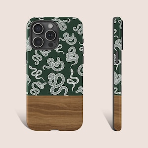 May include: A smartphone case with a dark green upper section featuring a white snake pattern. The lower section has a wood grain design. The side view shows the snake pattern continuing on the side of the case.