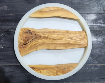 May include: A white circular resin tray with three pieces of natural wood embedded in the resin. The wood has a light brown color with dark brown grain patterns.