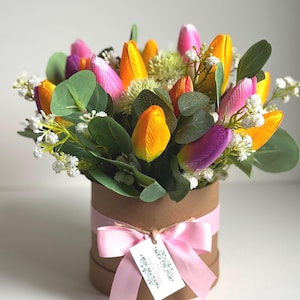 May include: A bouquet of colorful tulips in shades of pink, orange, and purple, arranged in a brown hatbox with a pink ribbon and a small tag that reads "Simply Flowers".