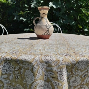 Może przedstawiać: Beige obrus z białym wzorem kwiatowym i brązowym i białym ceramicznym dzbanem na górze.