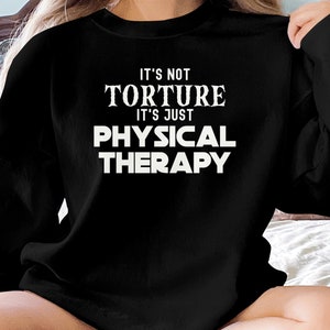 May include: Black sweatshirt with white text that reads "It's not torture it's just physical therapy."