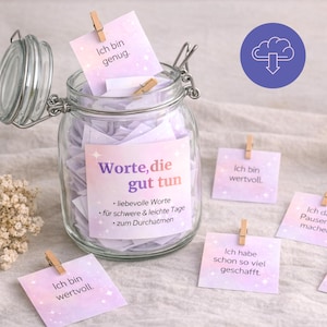 Peut inclure: Un bocal en verre transparent avec un couvercle à loquet métallique rempli de petites notes carrées en papier avec un fond dégradé violet et rose et des motifs d'étoiles. L'étiquette indique "Worte, die gut tun" avec du texte allemand. Des notes sont fixées avec des pinces en bois.