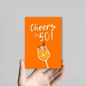 May include: Orange card with the text "Cheers to 50!" in white. A cartoon illustration of a glass of orange juice with two straws is in the bottom center of the card.