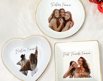 May include: Three white ceramic trinket dishes with gold rims. One is round, one heart-shaped, and one square. Each dish features a photo and the words "Sisters Forever," "Besties Forever," and "Best Friends Forever."