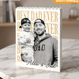 May include: A customized block featuring a black and white photo of a man and a child, with the text "BEST DAD EVER" in gold. The block also includes the names "Alex & Dad" at the bottom. The word "CUSTOMIZED" is in the top right corner.