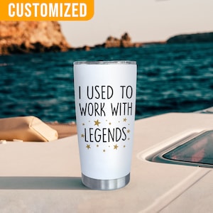 K&ouml;nnte beinhalten: Ein wei&szlig;er Edelstahlbecher mit dem Text "I USED TO WORK WITH LEGENDS" in Schwarz und goldenen Sternen. Der Becher hat einen silbernen Boden und einen Deckel. Das Wort "CUSTOMIZED" befindet sich in einem gelben Feld oben links.