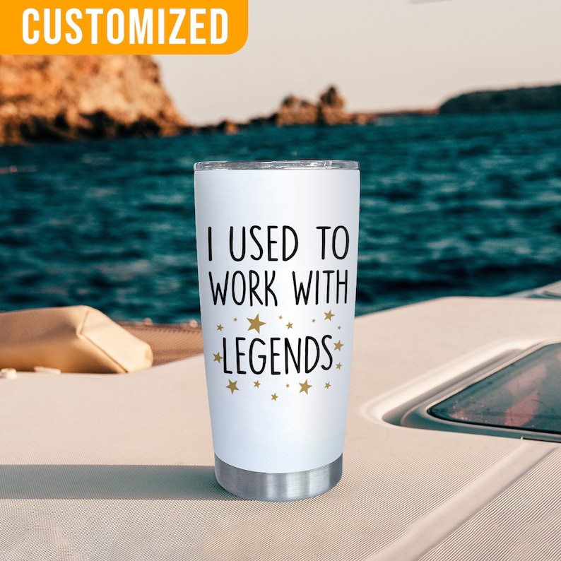 K&ouml;nnte beinhalten: Ein wei&szlig;er Edelstahlbecher mit dem Text "I USED TO WORK WITH LEGENDS" in Schwarz und goldenen Sternen. Der Becher hat einen silbernen Boden und einen Deckel. Das Wort "CUSTOMIZED" befindet sich in einem gelben Feld oben links.