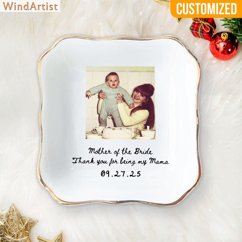May include: A white ceramic dish with a gold rim, featuring a vintage photograph of a mother and child. The text "Mother of the Bride" and a personal message are printed on the dish. The dish is square with wavy edges.