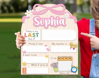 May include: A light-colored wooden sign with a pink bow and daisy graphic at the top. The text reads Sophia, Today is my LAST day of, Things I love, My teacher is, I want to be, When I grow up, and Date. It includes blank spaces for writing.