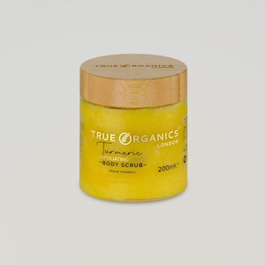 Może przedstawiać: Słoik z peelingiem do ciała z kurkumą True Organics. Cylindryczny słoik ma drewnianą pokrywkę. Żółty peeling zawiera napis "Turmeric - Body Scrub - Vegan Friendly" i "200ml".
