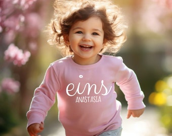 Geburtstagsshirt "eins" plus Name, kuscheliges Biobaumwoll Top, personalisierbares langarm Shirt erster Geburtstag, Ehrentag Kleidung Baby