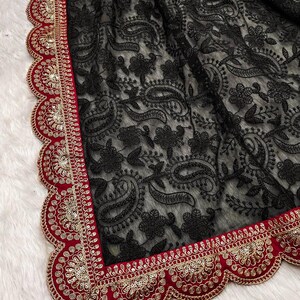 Pu&ograve; includere: Tessuto in rete nero con un motivo paisley e un bordo ricamato rosso e oro. Il bordo ha un bordo a festoni ed &egrave; decorato con paillettes.