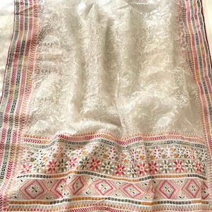 May include: A white sheer dupatta with intricate floral embroidery in white thread. The dupatta has a colorful border with pink, orange, and green embroidery.