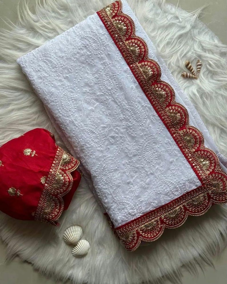 Pu&ograve; includere: Tessuto bianco ricamato con un bordo a festoni rosso e oro. Il tessuto &egrave; piegato a met&agrave; e un pezzo di tessuto rosso ricamato &egrave; sopra.
