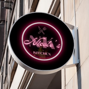 May include: A round, illuminated sign for "Nicole's Kitchen" with a black background and a pink neon border. The sign features the initials "NK" in a cursive font, along with a knife and fork icon.