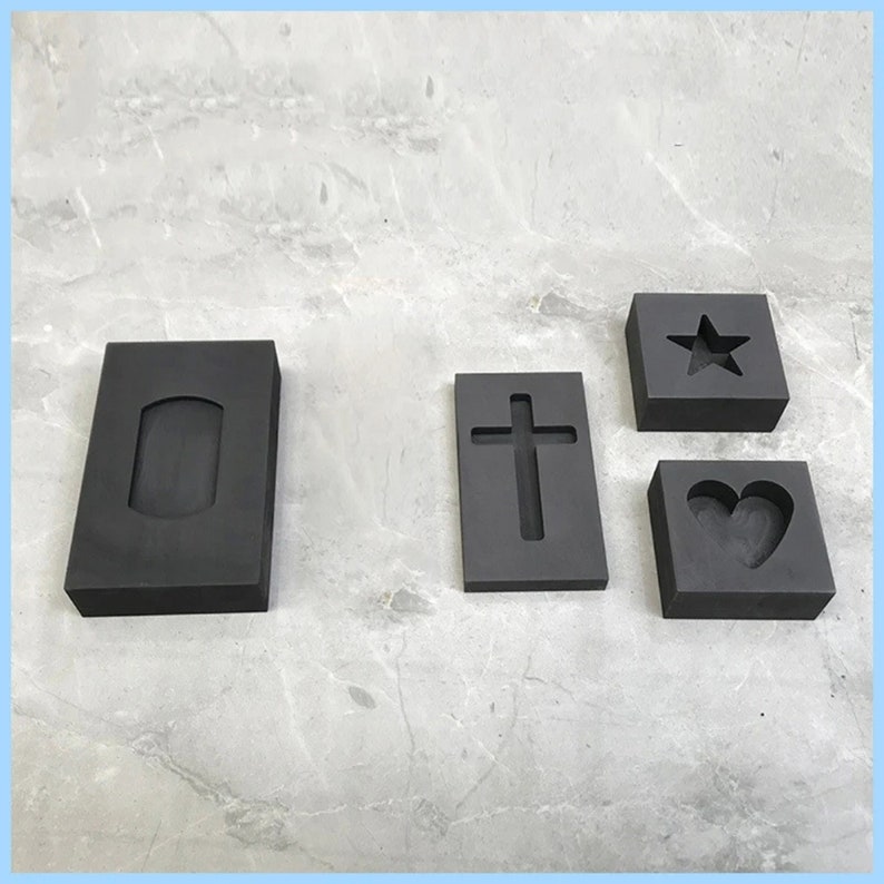 Puede incluir: Cuatro moldes de caucho negro para fundir metal. Los moldes son rectangulares y tienen diferentes formas cortadas: un rect&aacute;ngulo, una cruz, una estrella y un coraz&oacute;n.