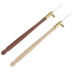 May include: Two wooden threader needles with brass tips and a small knob. One needle has a brown wooden handle and the other has a natural wood handle.