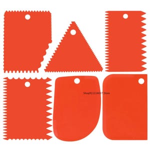 May include: Set of six red plastic cake decorating tools. The tools have different shapes, including a triangle, a rectangle, and a rounded shape. The tools have a hole in the top for hanging.