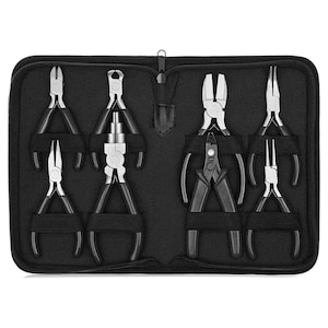 May include: A set of six black-handled pliers in a black zipped case. The pliers are arranged in two rows of three, with the handles facing up. The pliers are made of metal and have different types of tips.