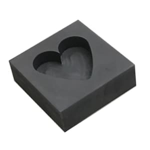 Puede incluir: Un molde cuadrado gris con un recorte en forma de coraz&oacute;n. El molde est&aacute; hecho de un material que parece goma o silicona.