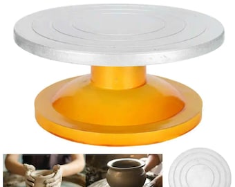 May include: A pottery wheel with a white ceramic top and a yellow base. The wheel is used for shaping clay.