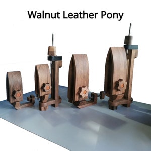 May include: Five walnut leather working pony clamps with adjustable height and a metal clamp. The clamps are made of wood and have a natural finish.