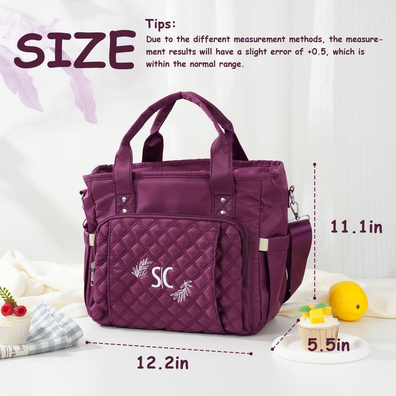 May include: A plum-colored tote bag with a quilted front pocket, embroidered with "SIC" and a leaf design. The bag has a top handle and a shoulder strap. Dimensions are 12.2 inches wide, 11.1 inches high, and 5.5 inches deep.