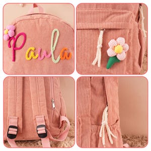 May include: Pink corduroy backpack with the name "Paula" embroidered in colorful letters. Features include a front pocket with a flower applique, adjustable straps, and a top handle. The backpack has a zipper closure and side pocket.