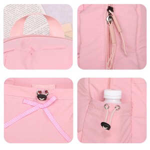 May include: Pink backpack with a top handle, zipper, and drawstring pocket. The backpack has a small frog-shaped clasp and a pink and white checkered ribbon. A white water bottle is in the side pocket.