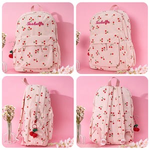May include: Pink corduroy backpack with a cherry print and the name "Isabella" embroidered on the front. The backpack has a small pocket on the front and a zipper closure.