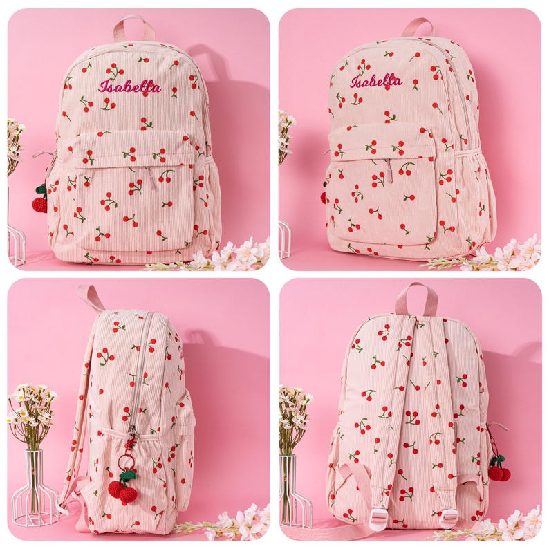 May include: Pink corduroy backpack with a cherry print and the name "Isabella" embroidered on the front. The backpack has a small pocket on the front and a zipper closure.