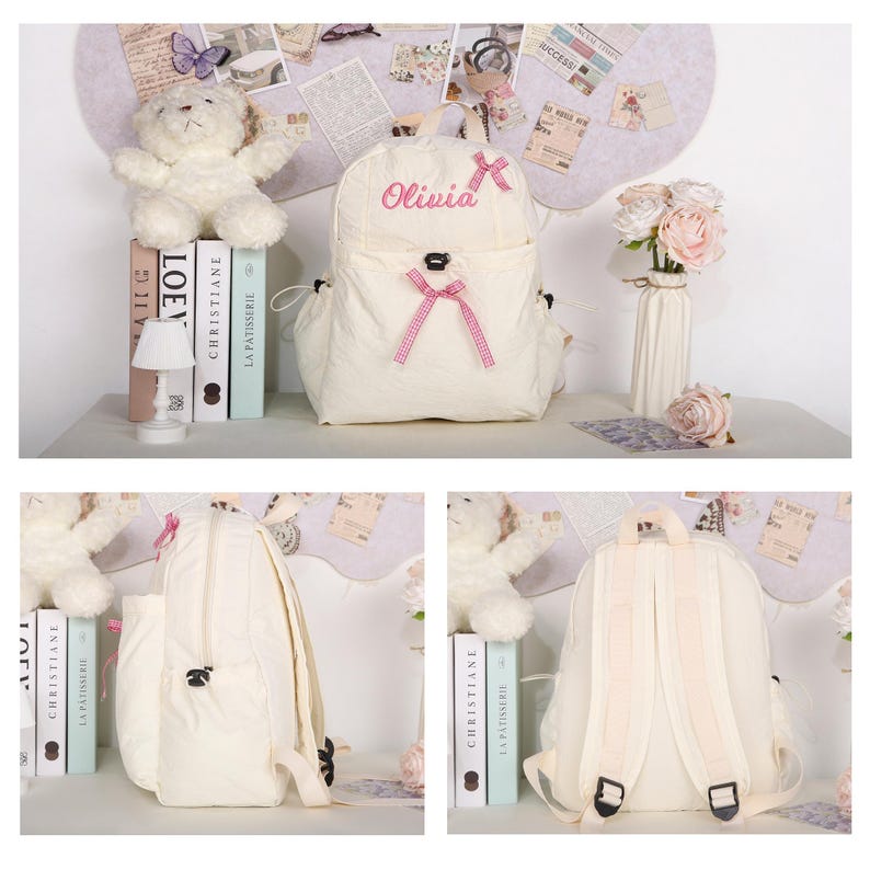 May include: Cream-colored backpack with the name "Olivia" embroidered in pink. The backpack features a front pocket with a pink bow and adjustable straps. A teddy bear, books, and a small lamp are visible in the background.