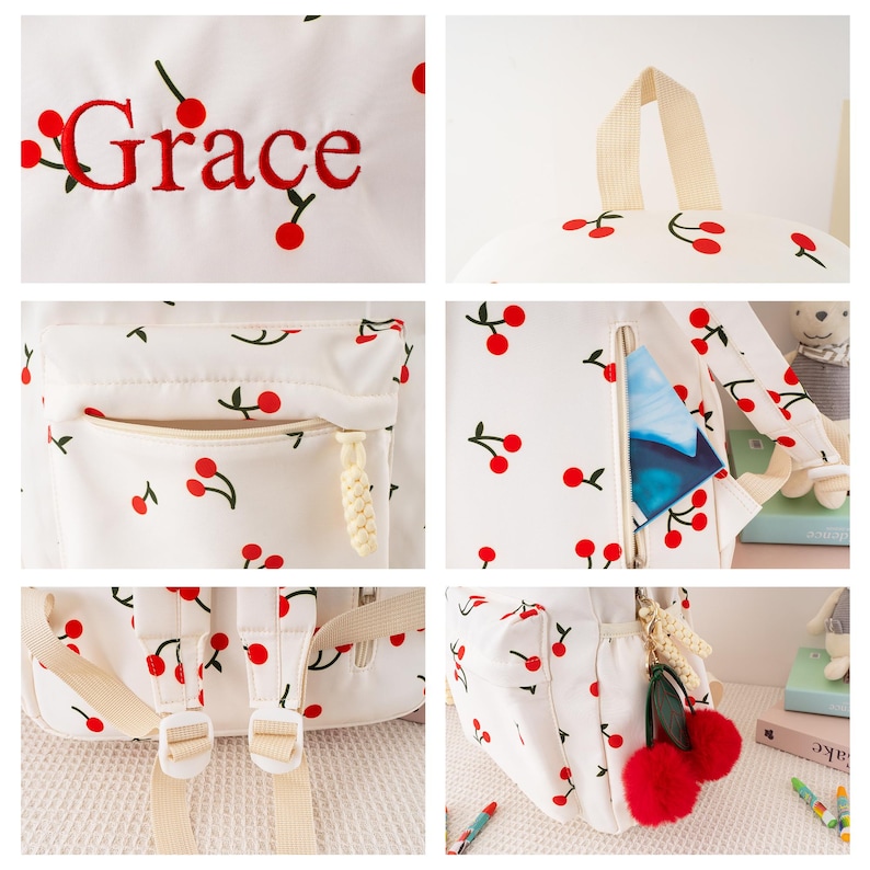 May include: White backpack with a cherry pattern and the name "Grace" embroidered in red. The backpack features a front pocket, adjustable straps, and a top handle. A red pom-pom cherry charm hangs from the zipper.