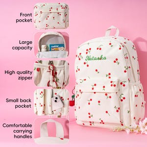 May include: White canvas backpack with a cherry print and the name "Natasha" embroidered on the front. The backpack has a front pocket, a large main compartment, a small back pocket, and comfortable carrying handles.