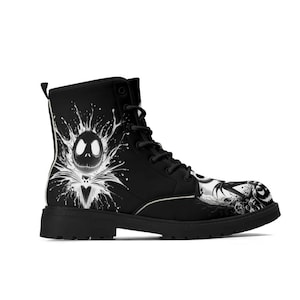 Könnte beinhalten: Schwarzer Kampfstiefel mit einer weißen Grafik von Jack Skellington aus The Nightmare Before Christmas. Der Stiefel hat ein Schnürdesign und eine dicke, schwarze Sohle. Das Kunstwerk enthält einen Spritzeffekt und befindet sich an der Seite und an der Spitze des Stiefels.