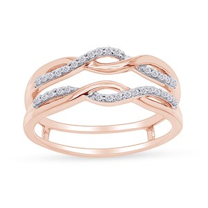 Op de afbeelding: Een ring van ros&eacute;goud met een dubbelband ontwerp. De banden zijn met elkaar verweven en bezet met kleine diamanten.