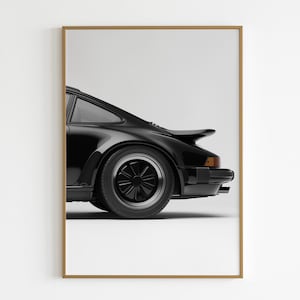 Puede incluir: Un Porsche 911 negro con un alerón trasero, visto de lado. El coche está aparcado sobre un fondo blanco.
