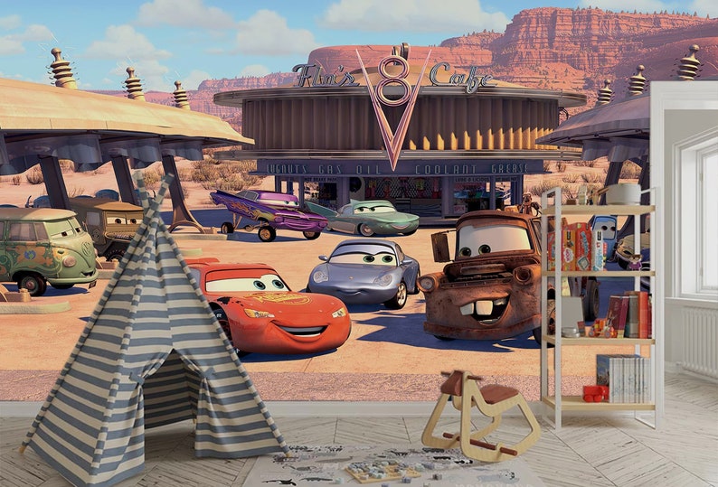 K&ouml;nnte beinhalten: Ein farbenfrohes Wandbild zum Thema Cars mit Lightning McQueen, Mater und anderen Figuren aus dem Film. Das Wandbild zeigt eine Tankstelle mit einem Schild, auf dem "Flo's V8 Cafe" steht.