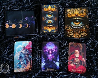 May include: A tarot deck guidebook titled "Queen's Pledge" with a gold and black cover featuring an eye design. The guidebook is displayed with four tarot cards: Knight of Wands, Temperance, King of Wands, and a card with a crescent moon design.