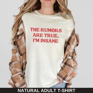 May include: A white t-shirt with the text "THE RUMORS ARE TRUE, I'M INSANE" printed in red.