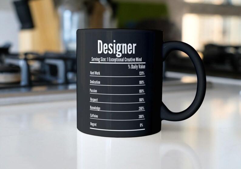 May include: Black ceramic coffee mug with the word "Designer" and a list of qualities and their daily value percentages. The qualities include hard work, dedication, passion, respect, knowledge, caffeine, and regret.