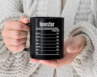 May include: Black coffee mug with white text that reads "Investor" and a list of qualities and their daily value percentages. The qualities include hard work, dedication, passion, respect, knowledge, caffeine, and regret.