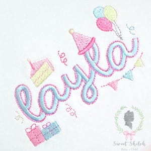 Puede incluir: Diseño bordado con el nombre "Layla" en azul claro con contorno rosa, adornado con elementos de fiesta como una tarta, globos y bolsas de regalo. El diseño incluye un gorro de fiesta y una guirnalda, todo en colores pastel. El logotipo de Sweet Shiloh está en la esquina inferior derecha.