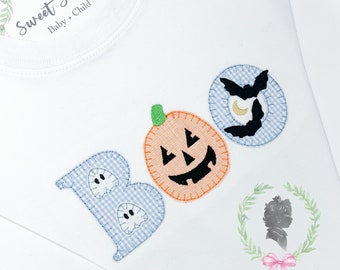 May include: A white long-sleeve shirt featuring an embroidered applique design that spells out BOO. The letter B is light blue gingham with two small ghosts, the O is an orange pumpkin, and the final O is a blue gingham circle with a black bat.