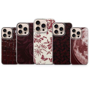 Może przedstawiać: Kolekcja pięciu etui na telefon z różnymi wzorami. Etui mają różne wzory, w tym fakturę skóry krokodyla, motywy róż, nadruki kwiatowe z motylami i wzór pełni księżyca. Kolory to odcienie bordowego i czerwonego.