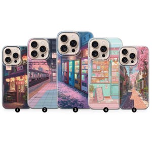 Puede incluir: Cinco fundas para teléfono con diseños coloridos de temática japonesa. Las fundas presentan ilustraciones de una escena callejera, una estación de tren, máquinas expendedoras, una tienda y una calle bordeada de cerezos en flor. Cada funda tiene un borde transparente.
