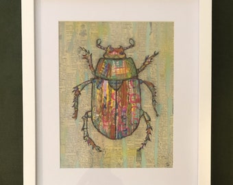 Puede incluir: Una obra de arte enmarcada que presenta un escarabajo colorido y estampado sobre un fondo texturizado. El escarabajo está hecho de varios materiales, incluyendo papel y tela, y tiene una combinación de colores verde, amarillo y rojo.