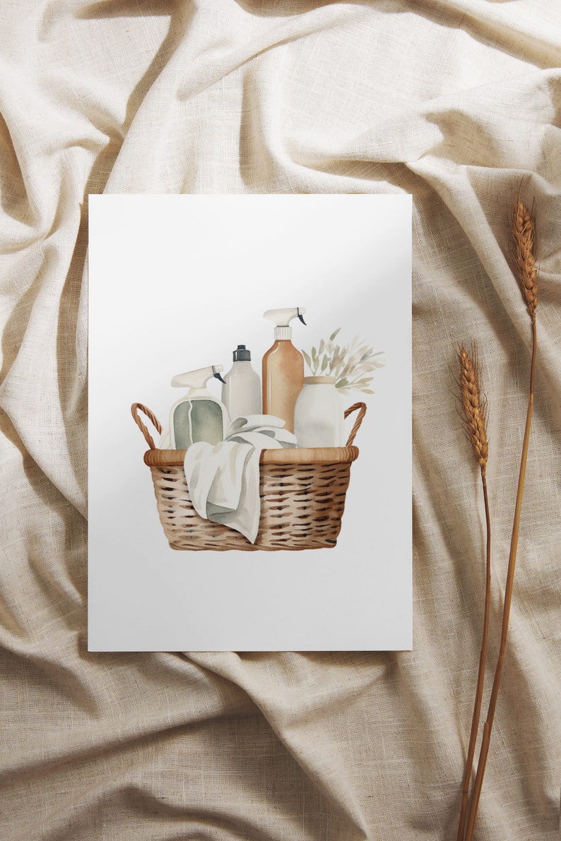 May include: A wicker basket filled with cleaning supplies, including spray bottles, a white towel, and a small vase with dried flowers. The basket is on a white background.